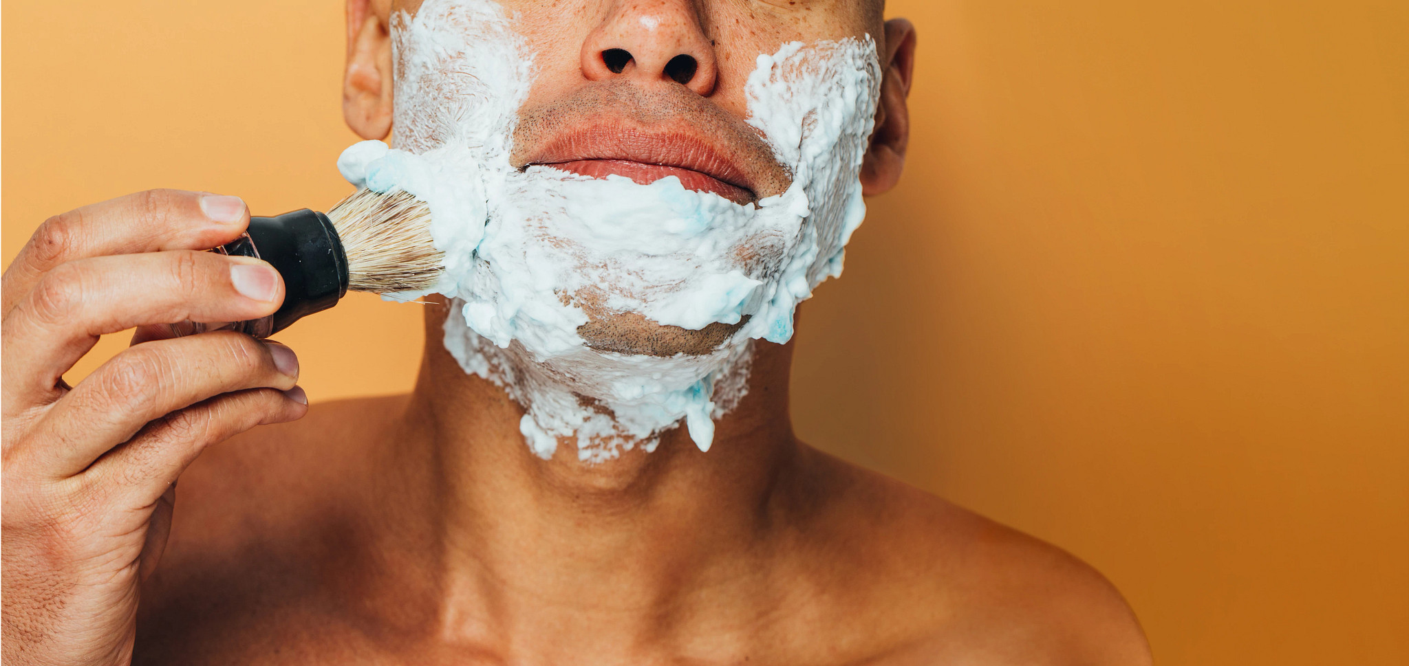 man applying shaving cream to his face