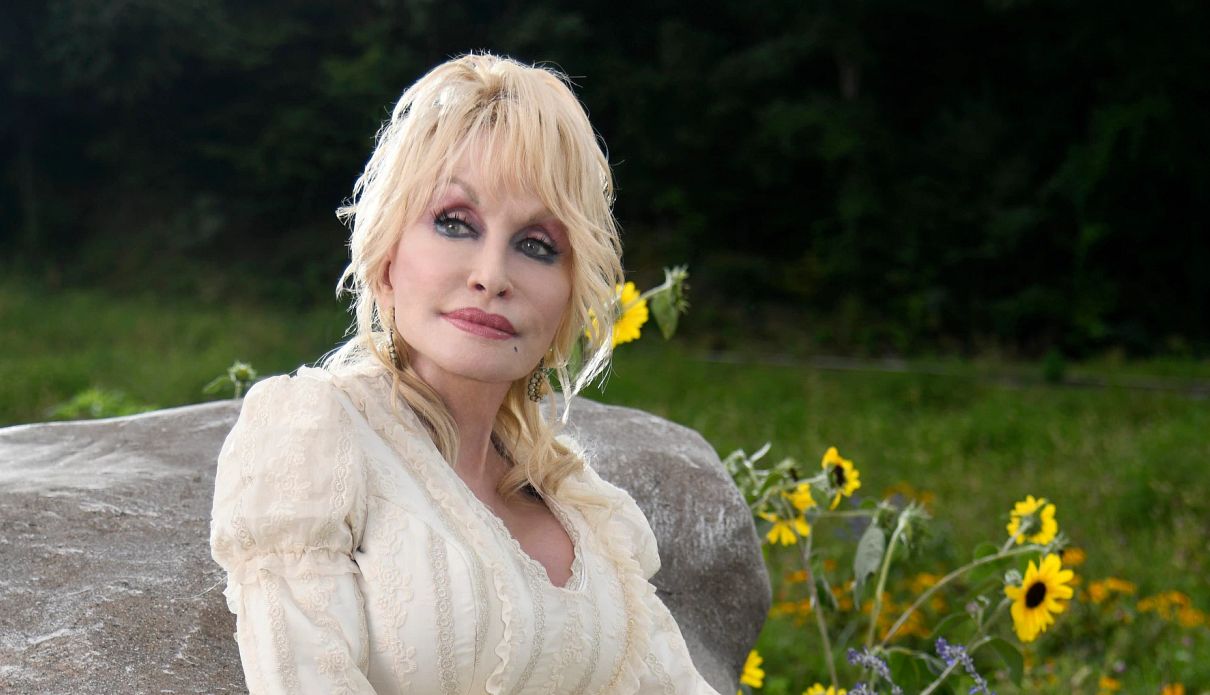 Dolly Parton Offers Advice on Grief dolly parton in an outdoor setting with yellow flowers