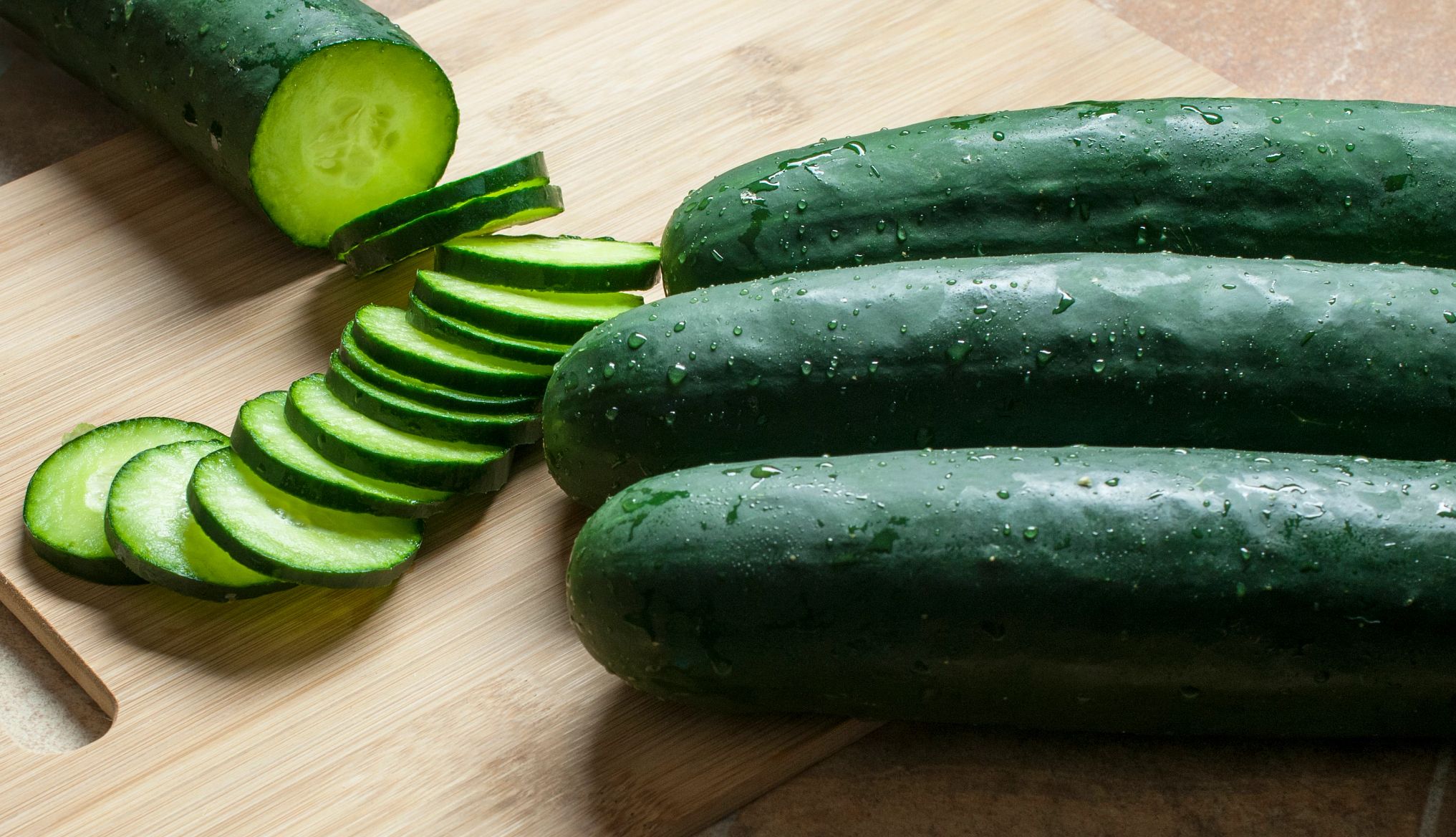 Cucumber Salmonella Outbreak cucumber slices on a wooden cutting board