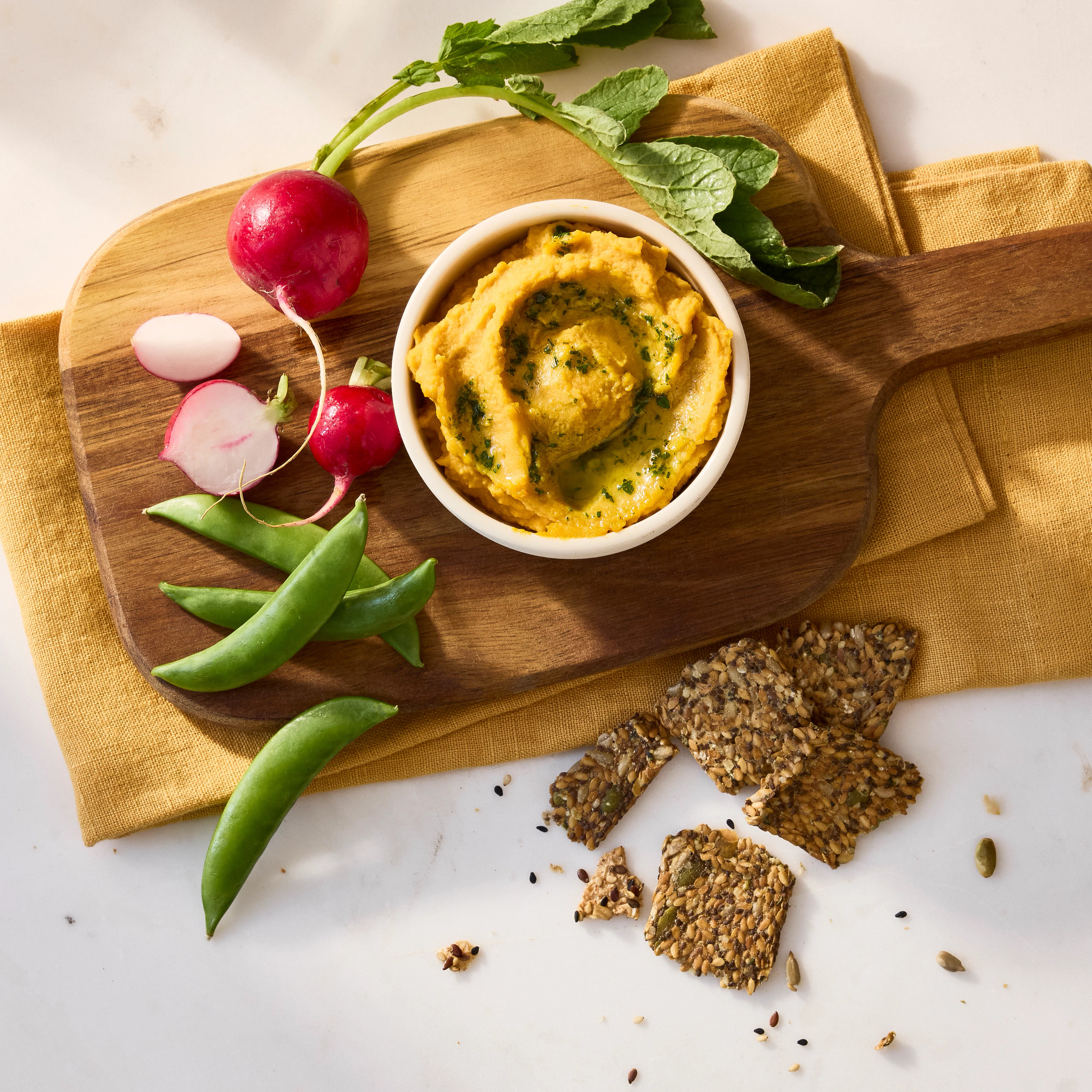 a photo shows pumpkin hummus with herb drizzle