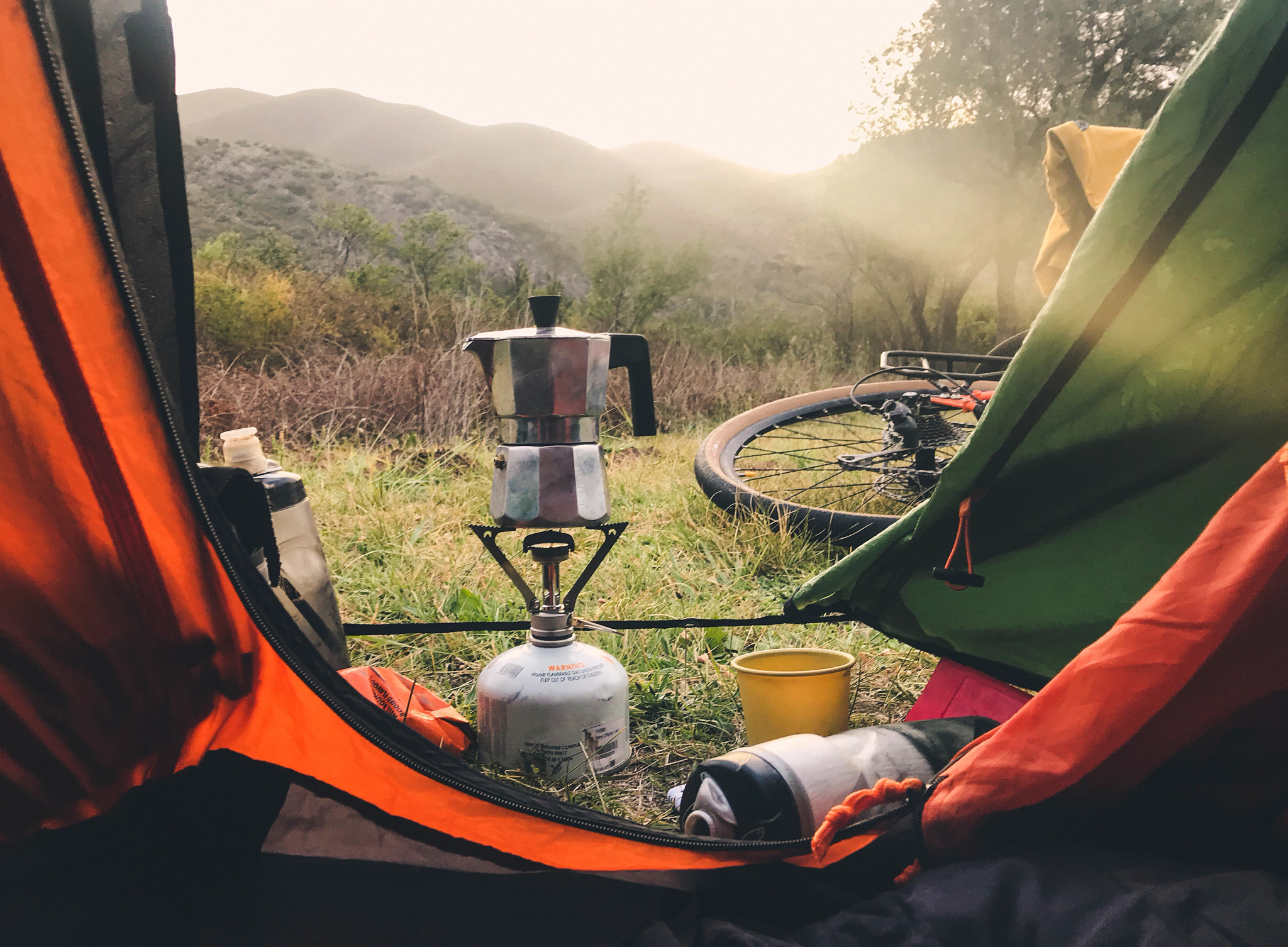 a kettle and bike outside a tent
