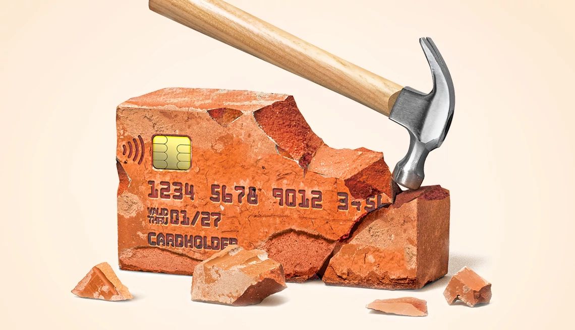 Break These Bad Money Habits a hammer breaks a credit card made of brick