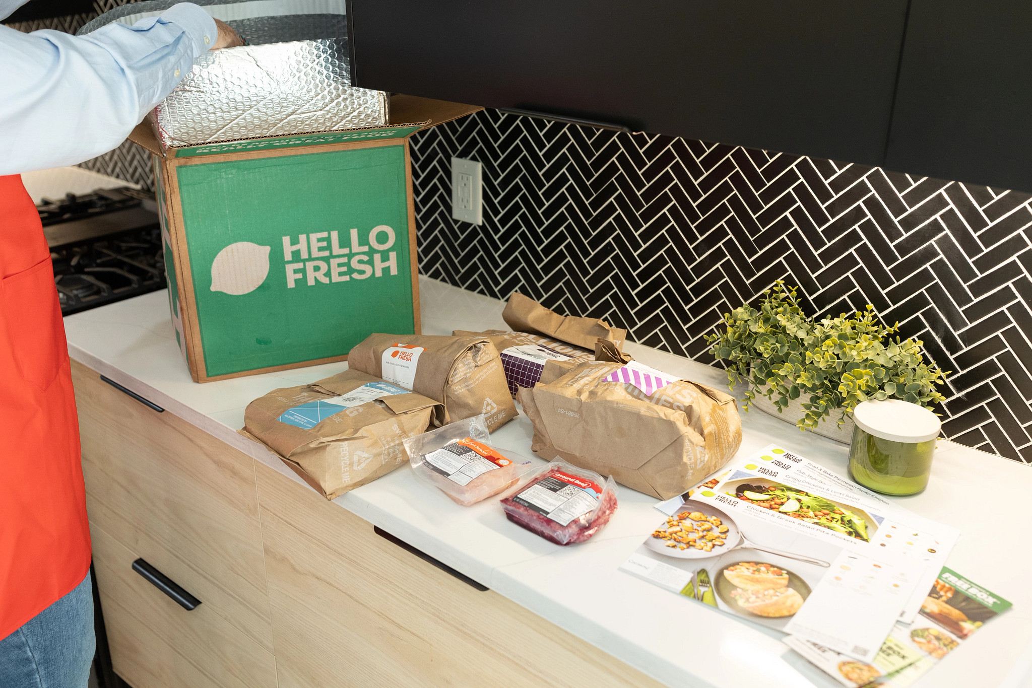 An older adult tester unpacking a HelloFresh meal delivery service box.