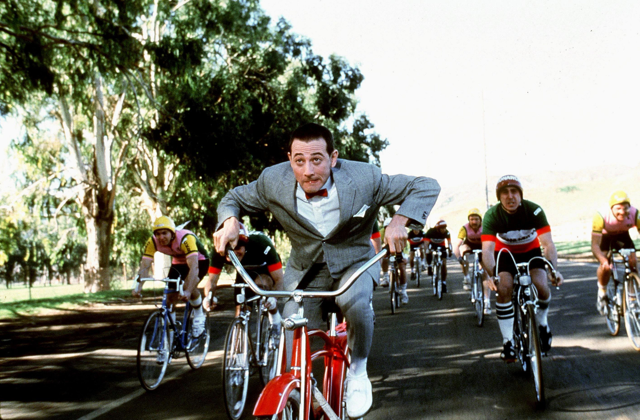 a scene from Pee-Wee's Big Adventure with the titular character riding on his iconic red bike 