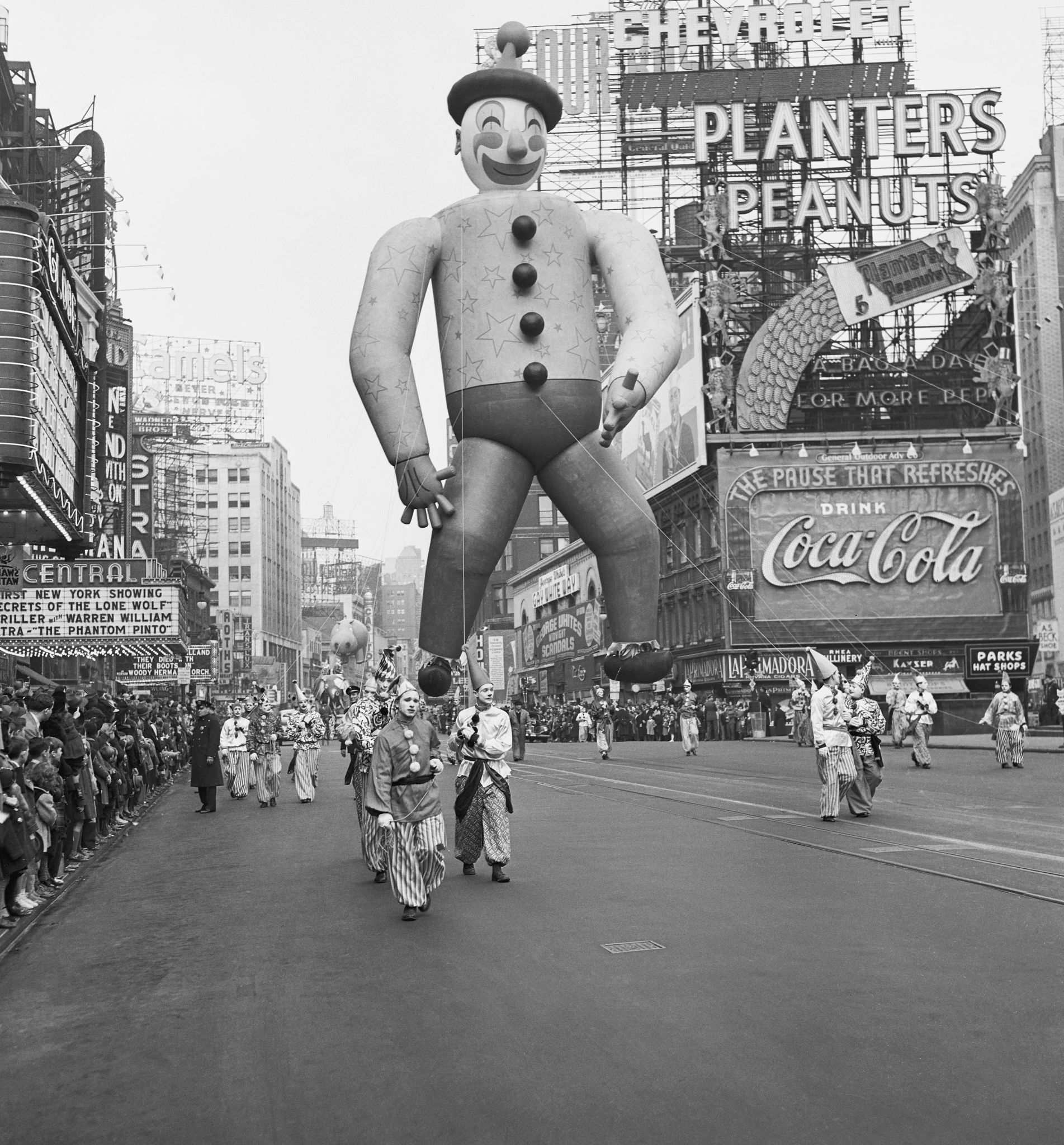 1941 Macy's Thanksgiving Day Parade people dressed as clowns carrying a giant clown balloon during a parade