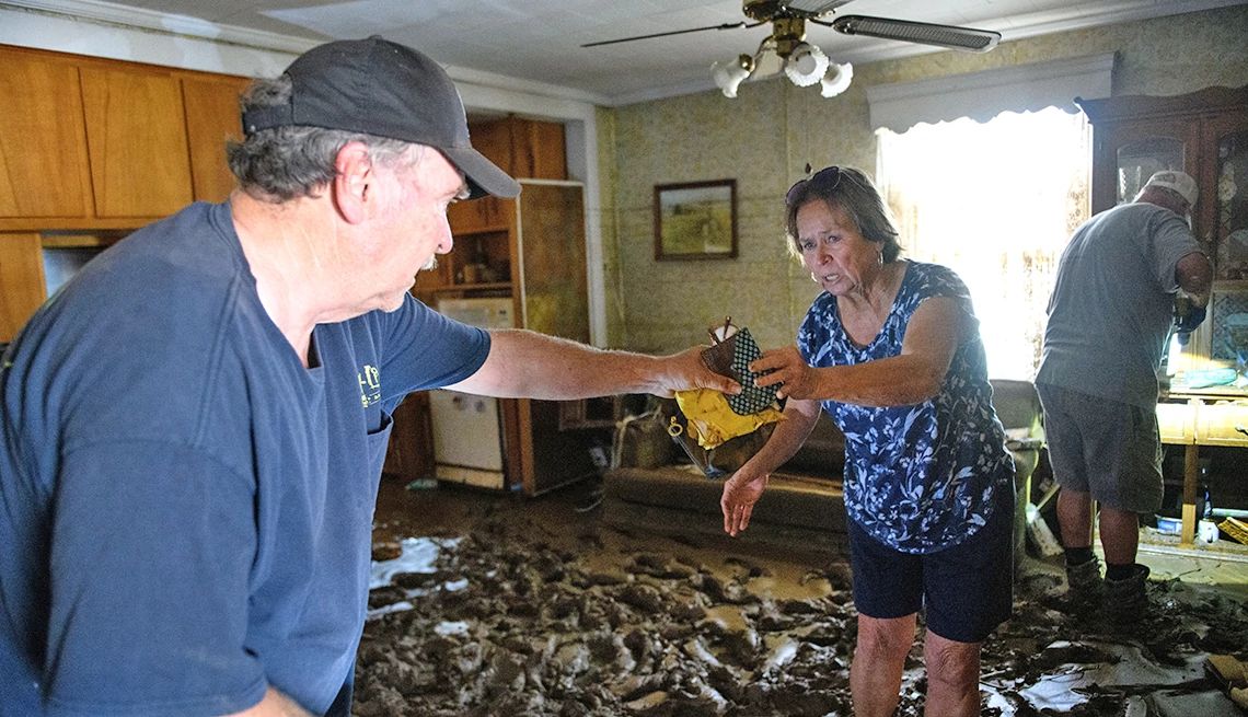 AARP Foundation's Relief Fund will help victims of Hurricane Helene A woman hands her brother salvaged items while they remove valuables from their flooded home