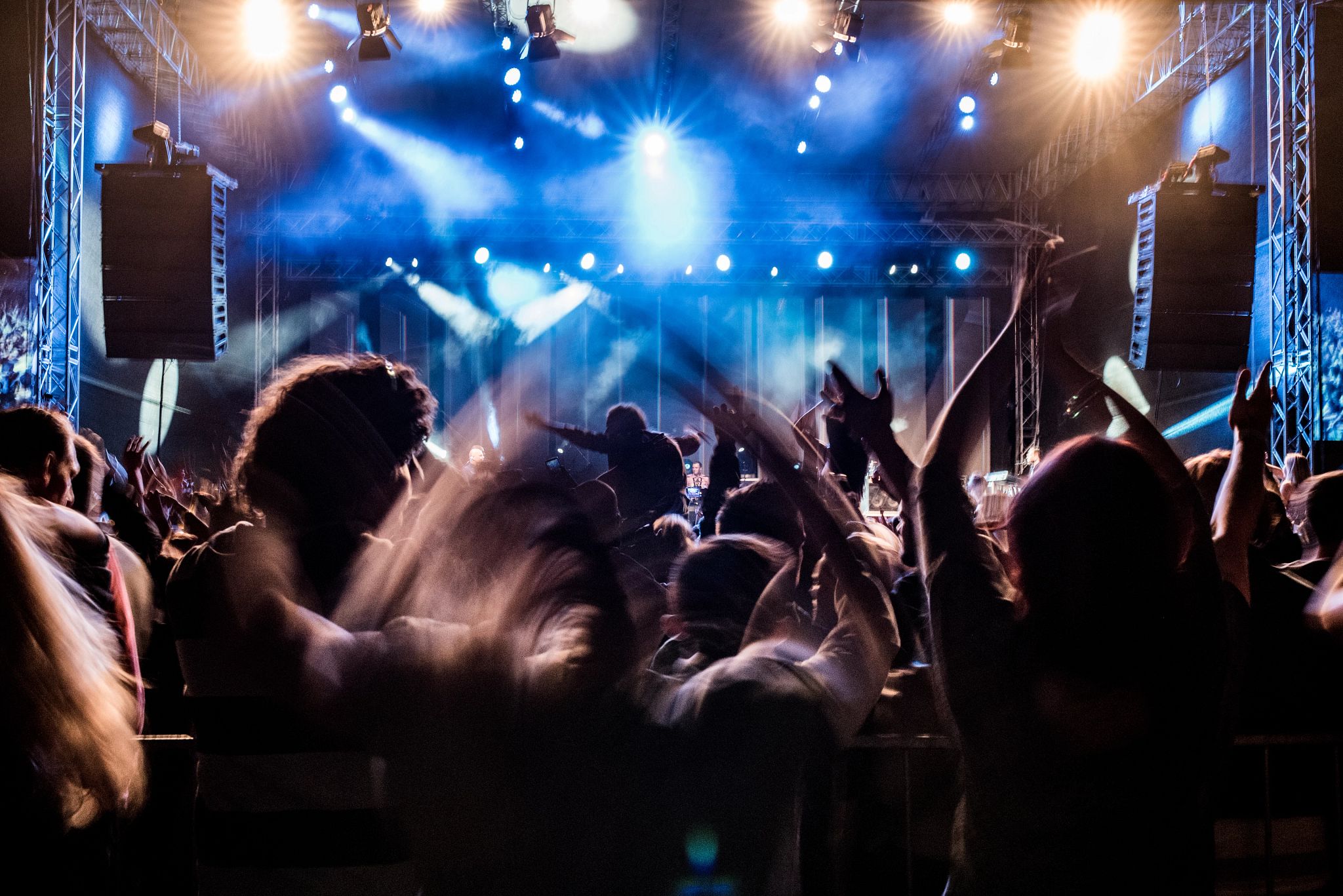 Fans with raised arms enjoying concert, people on open-air music festival Fans with raised arms enjoying concert, people on open-air music festival