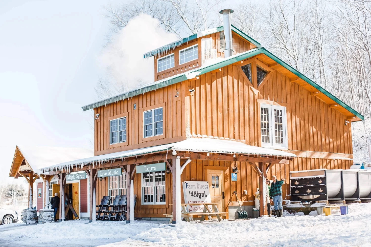 a maple farm with a snow covered store advertising maple syrup, live music and tours