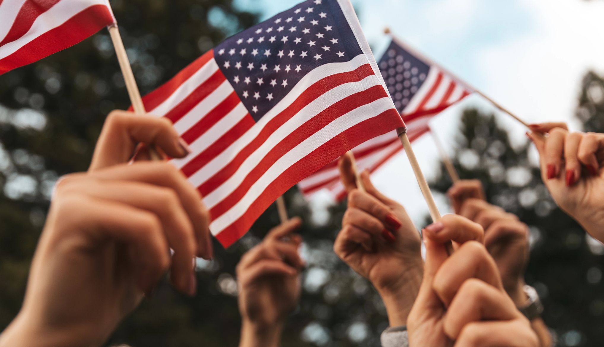 Military, Veteran Discounts on Travel, Entertainment and More hands hold miniature american flags