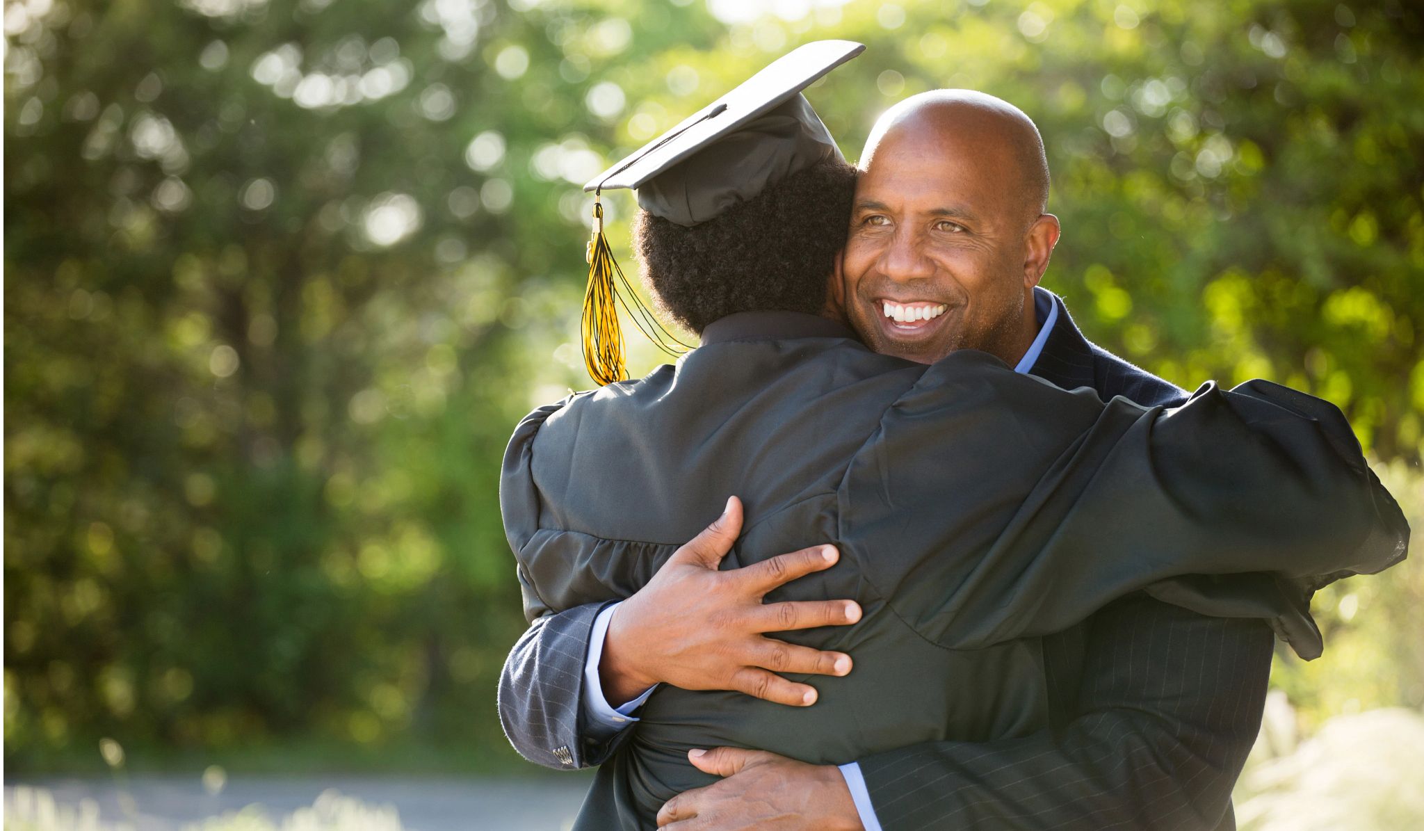 African American father hugging his son graduation day African American father hugging his son graduation day
