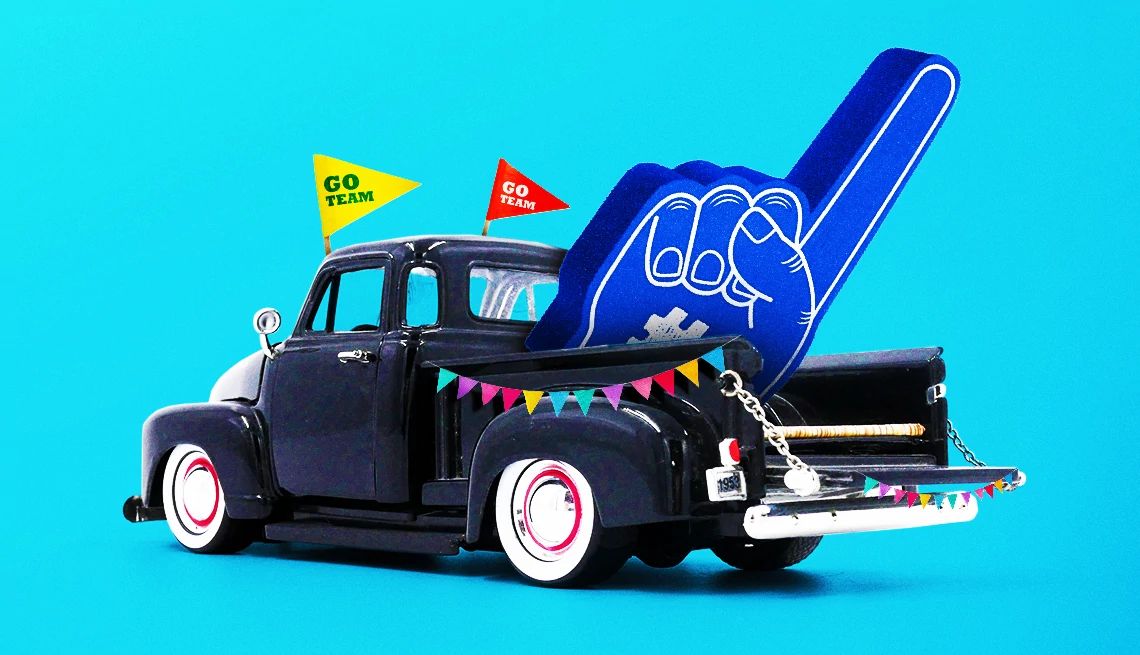 AARP Smart Guide to Tailgating A photo and graphic illustration shows a classic pickup truck in front of a blue background. Its tailgate is down and there is giant foam finger in the back.