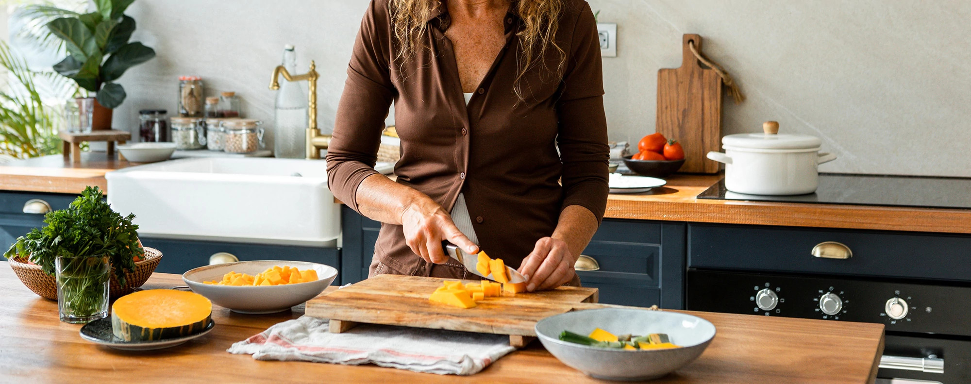 Mature woman using cutting board in her home kitchen