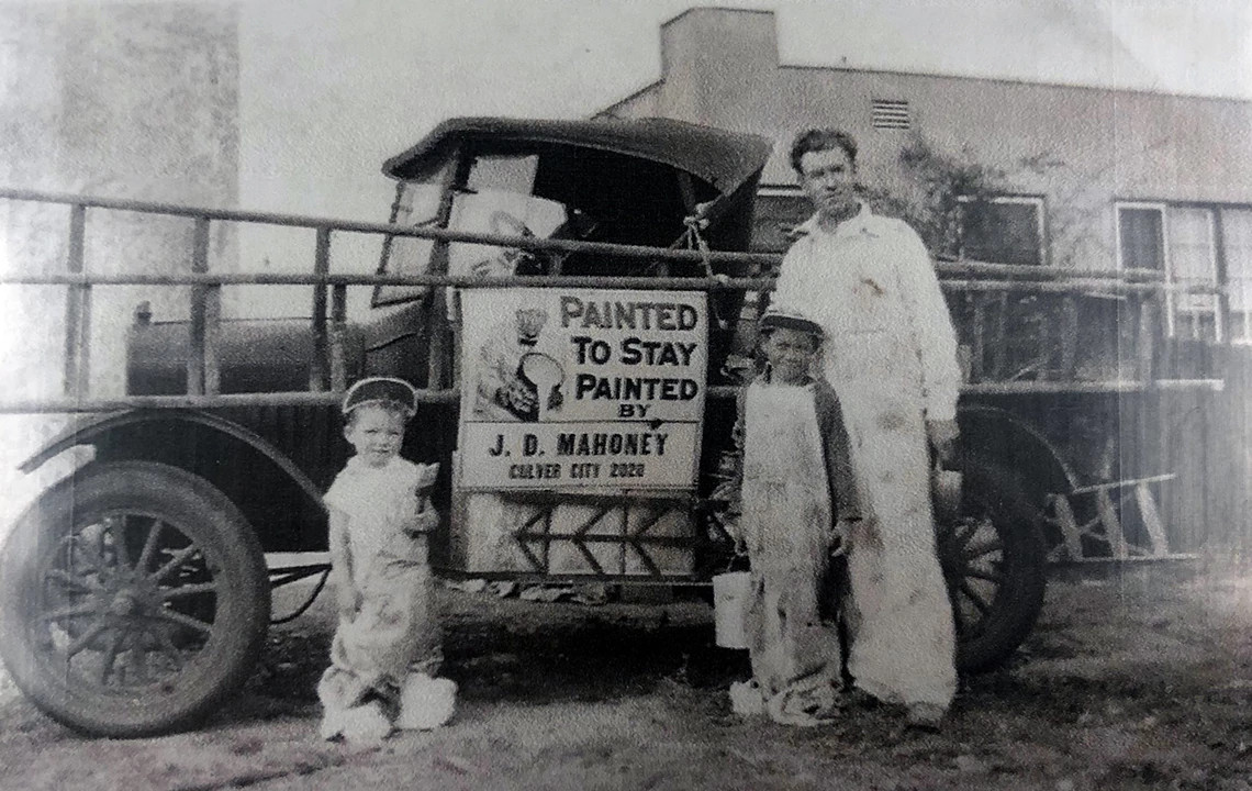 a man and two children stand in front of a car with a sign that reads painted to stay, painted by j d mahoney