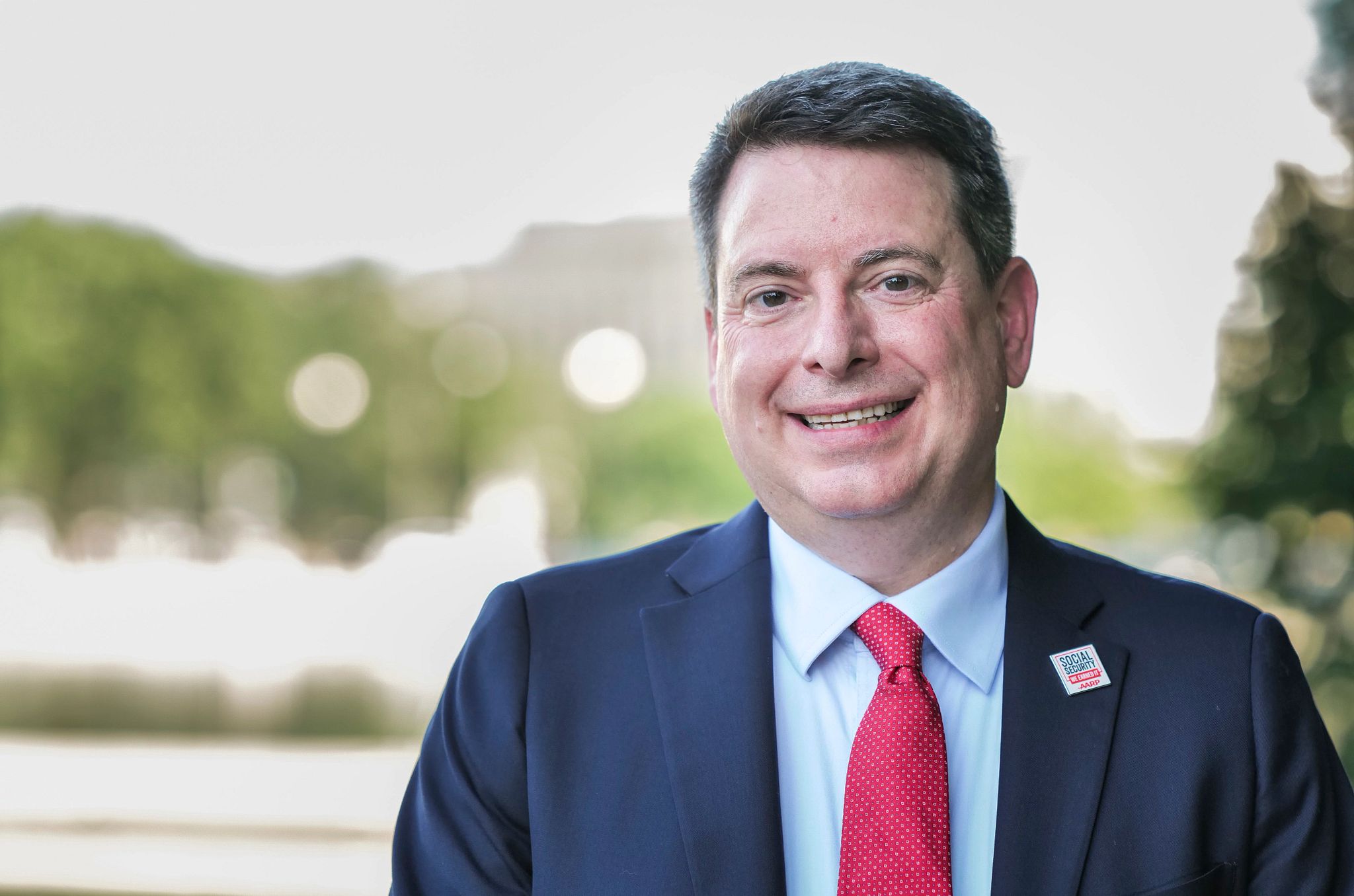 Bill Sweeney a man in a suit smiles for a picture
