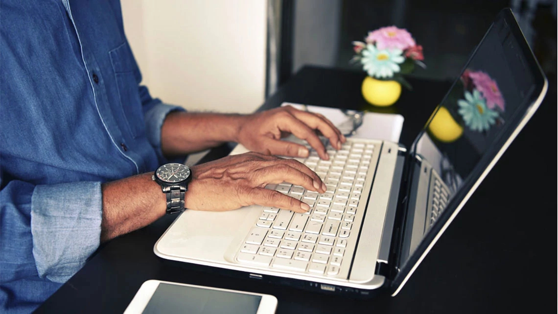 man typing on laptop