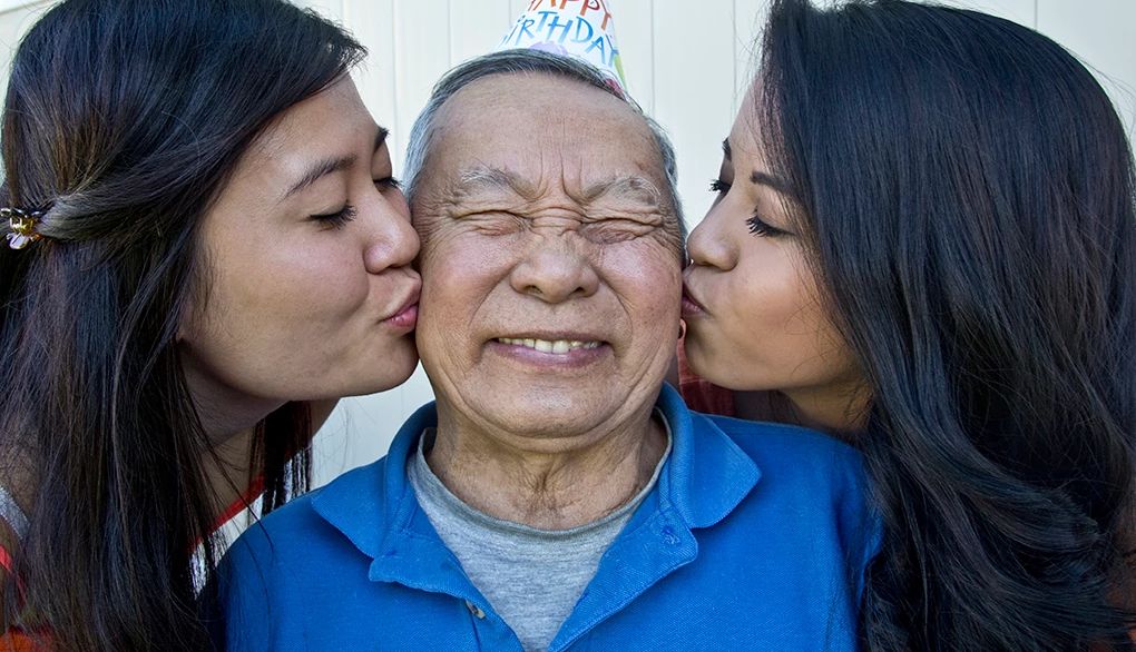 Having meaningful conversations is worthwhile Two younger women kissing an older man on both cheeks on his birthday