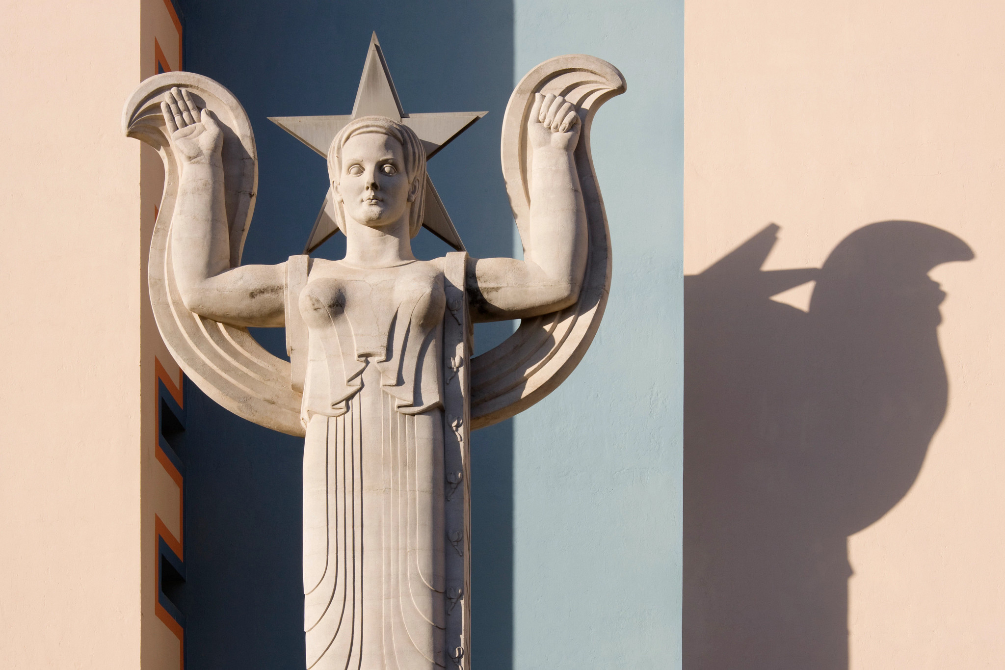 an art deco style sculpture of a woman with arms raised