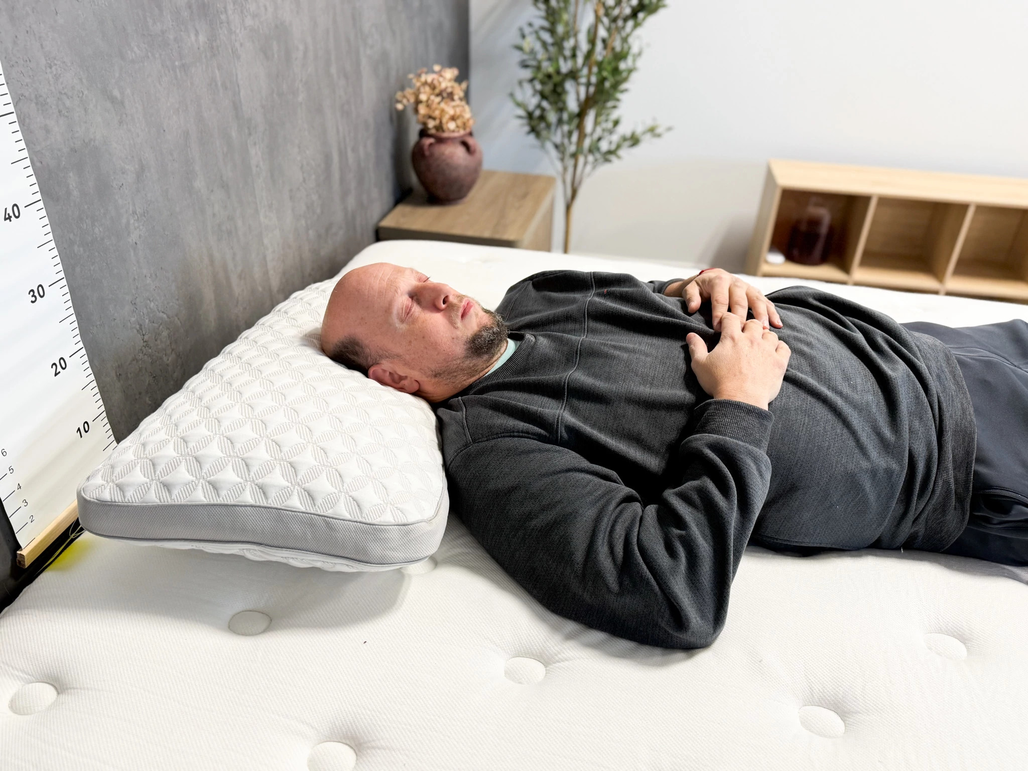 A man lying on his back on top of a mattress and the Brooklyn Bedding Talalay Latex pillow