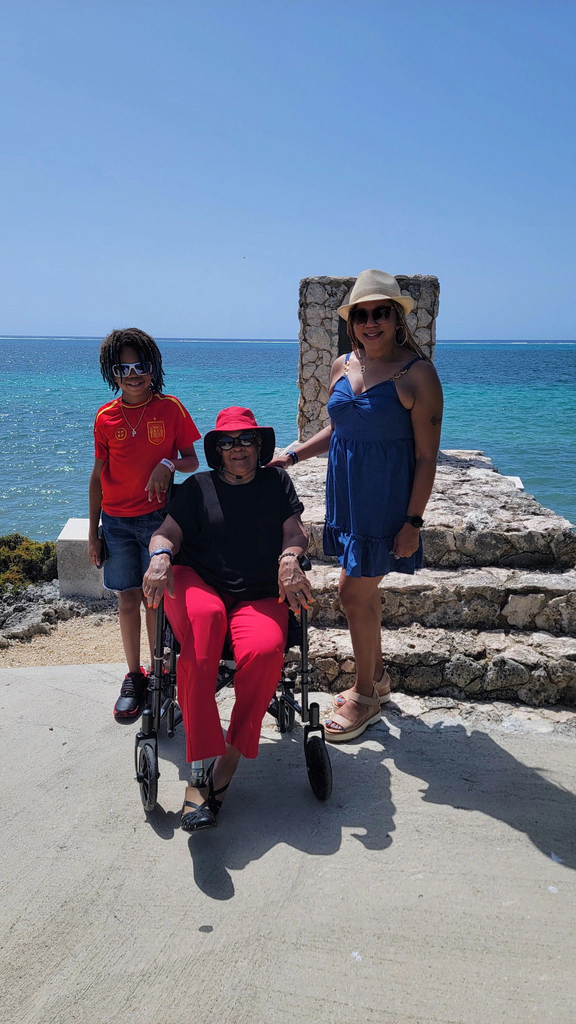a family poses for a photo with the ocean in the background