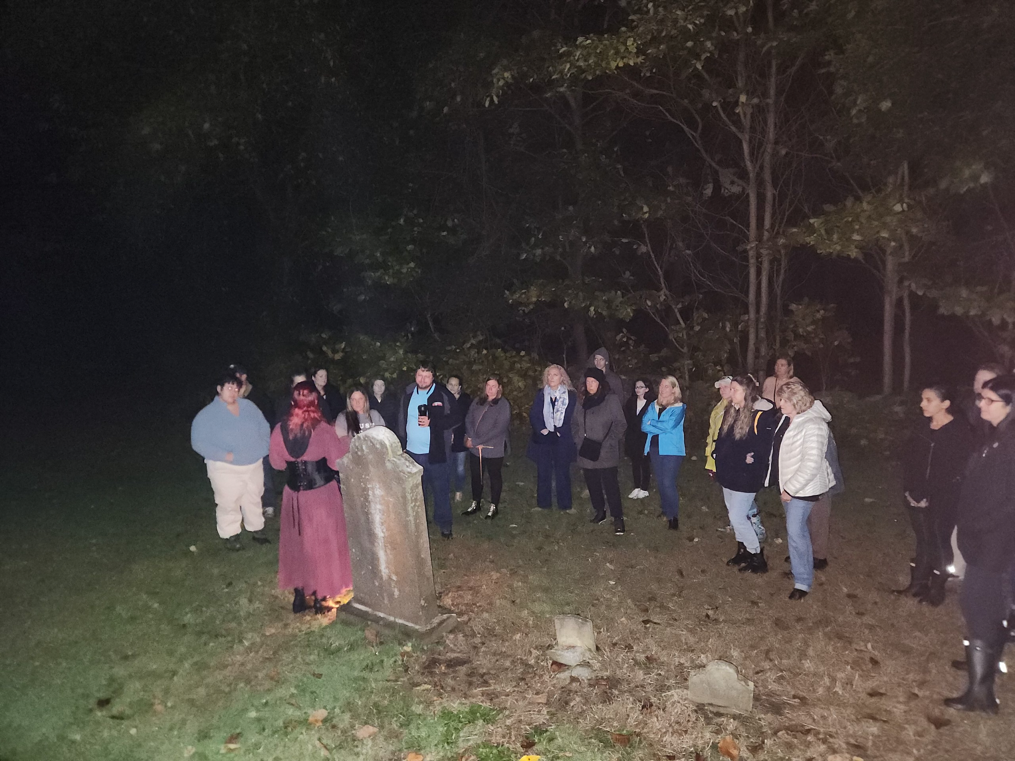 Personas en un cementerio en el recorrido de fantasmas en el cementerio a la luz de la luna de Mystic
