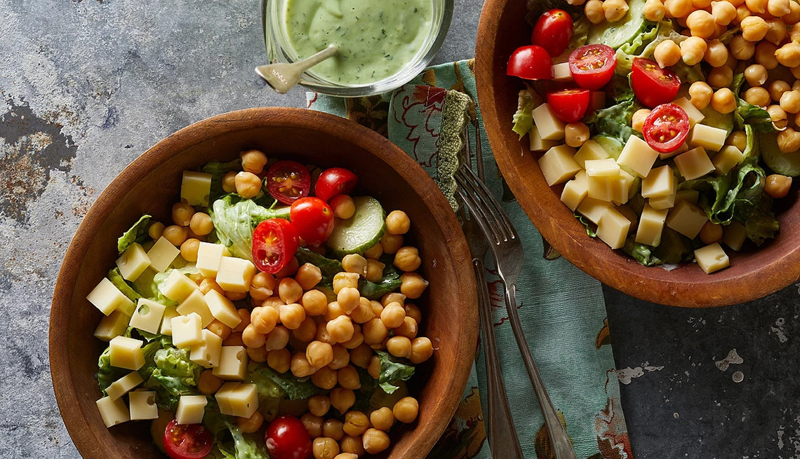 A close-up view of green goddess salad with chickpeas in bowls
