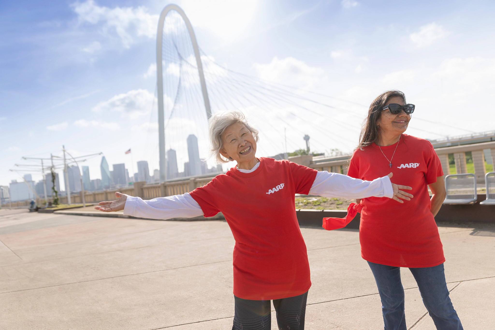 Dallas volunteers pose smiling with the Dallas skyline behind them
