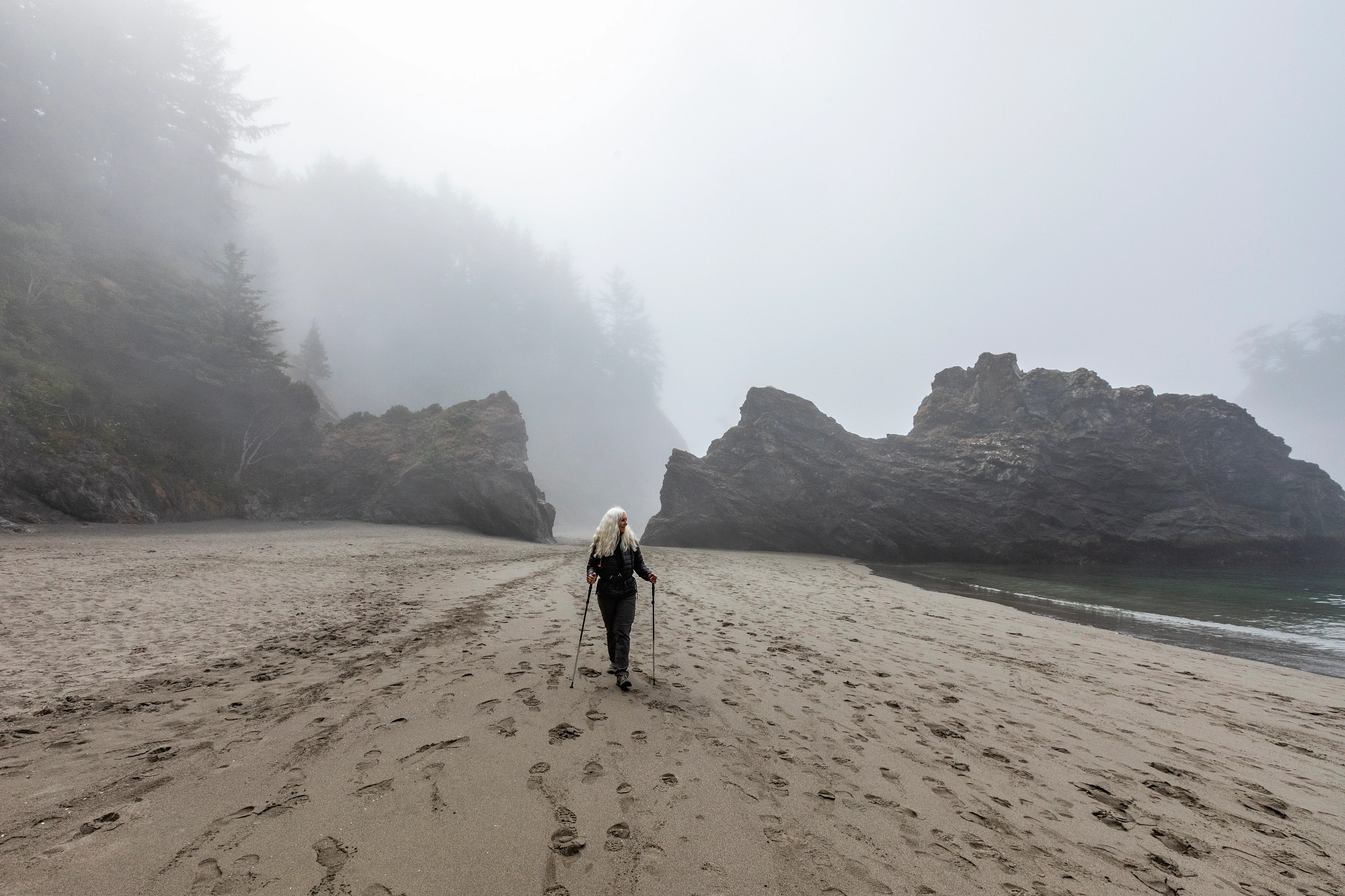 person walking on a foggy beach