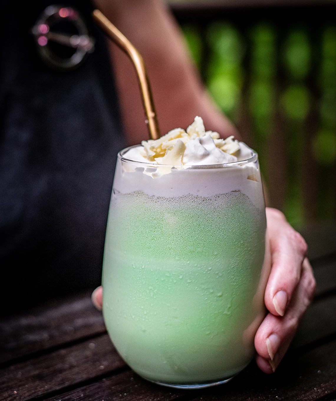 a person holding a glass of shamrock shake