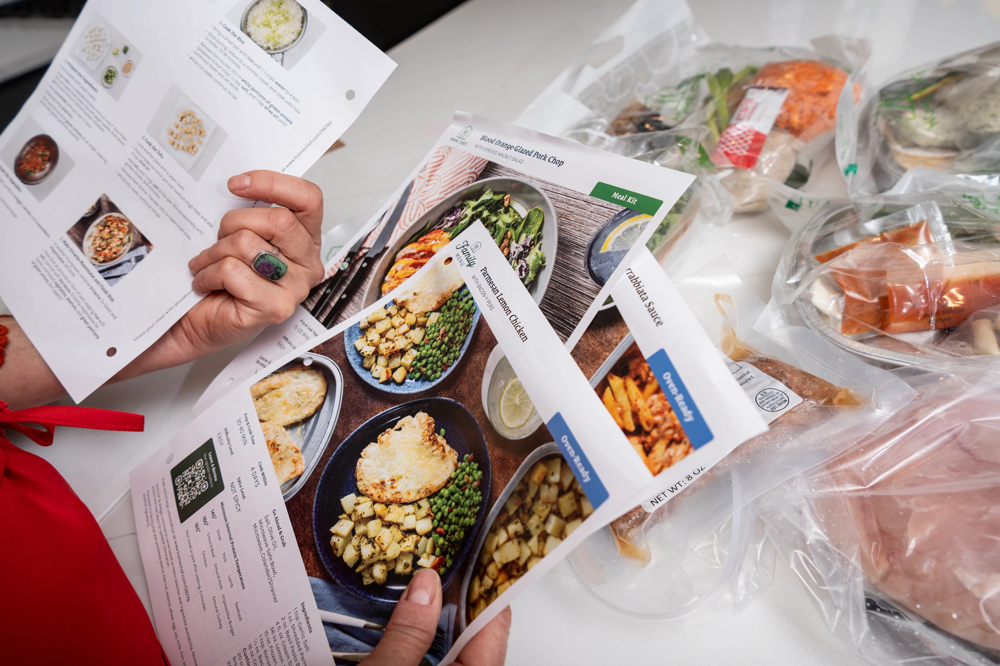An older adult tester looking through the recipe cards of her Home Chef meal kit.