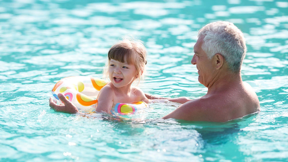 Grandfather & Granddaughter Playing In Pool