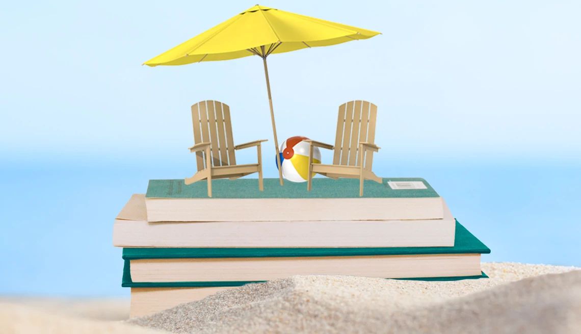 a stack of books in the sand with beach chairs and umbrellas on top