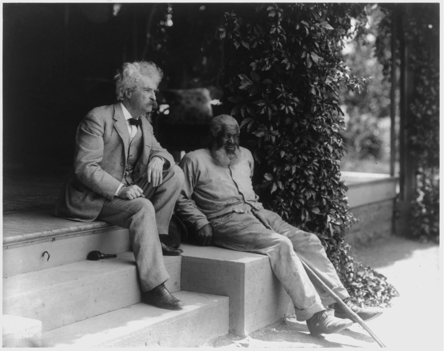 Mark Twain and John T. Lewis seated together on stairs