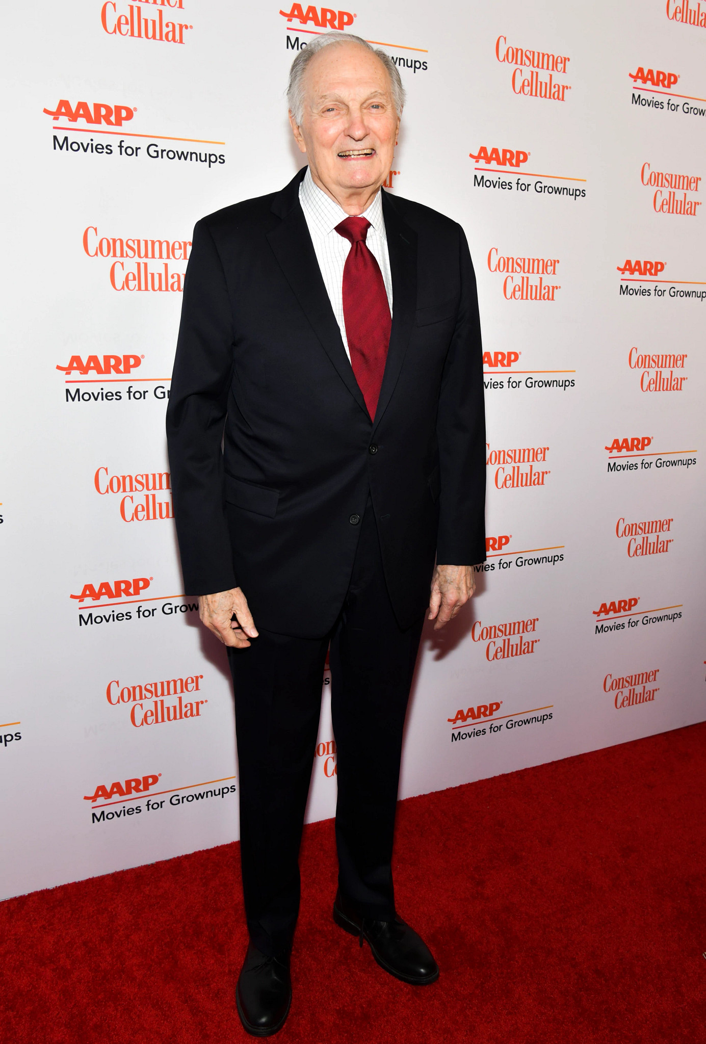 Alan Alda smiling at an AARP event.