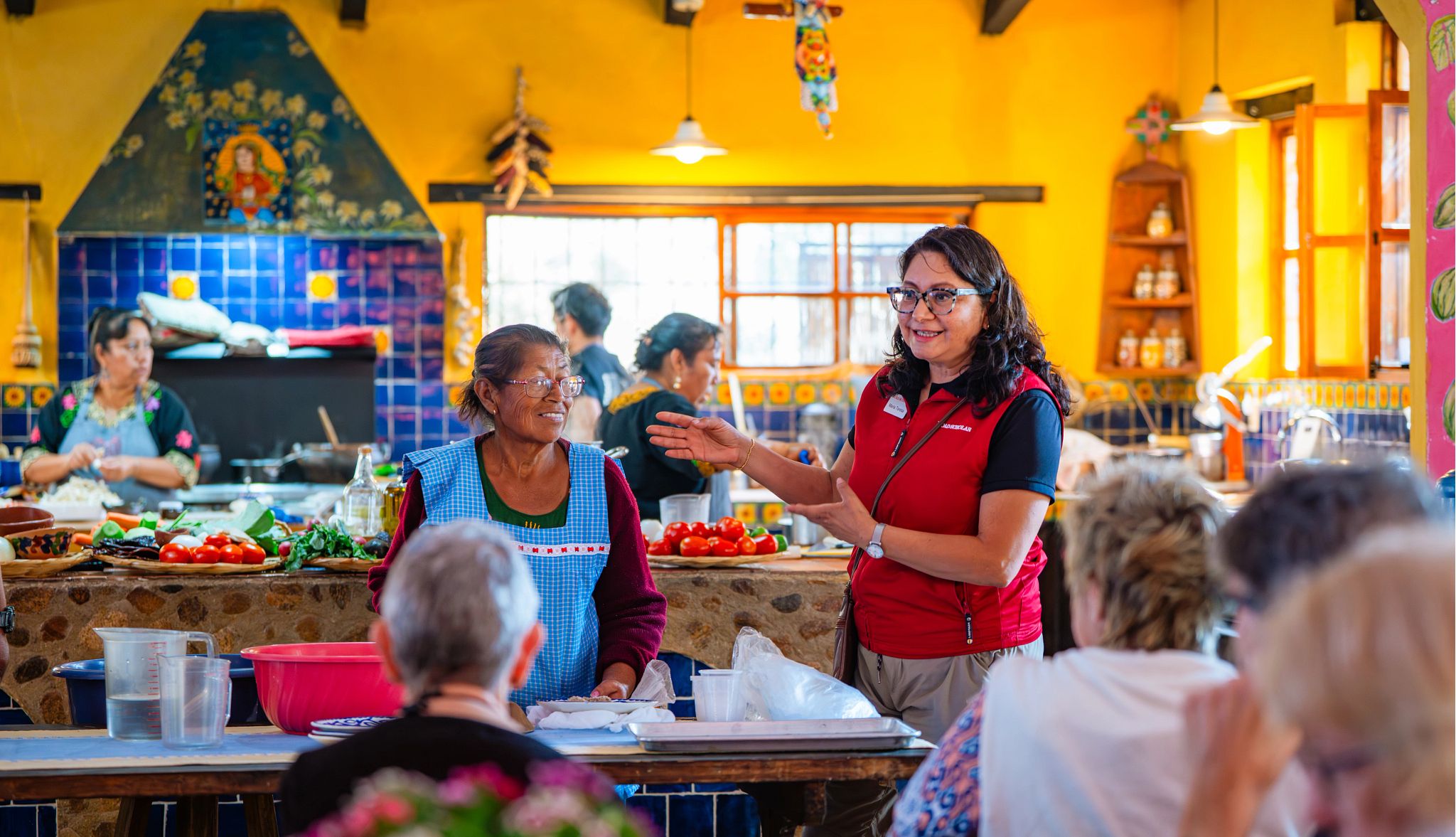 Affordable Off Peak Getaways an instructor talking during a cooking class in mexico