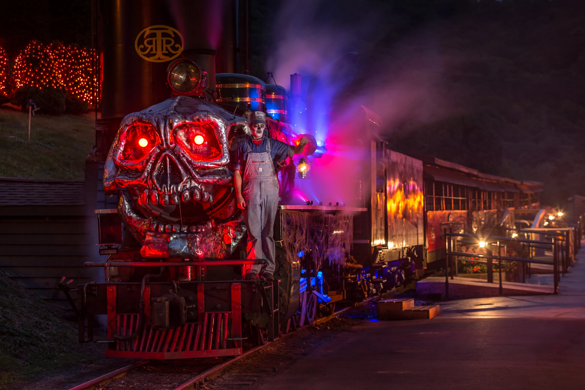 a train decorated in a skeleton mask with a man wearing skeleton makeup and wearing a train conductor costume