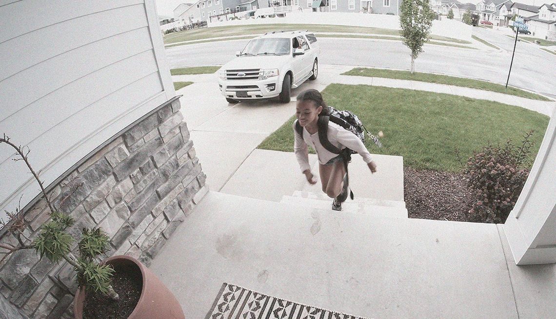 Your Smart Video Doorbell May Not Be Secure, Consumer Reports Testing Shows a person approaching a door and is being viewed through a video doorbell