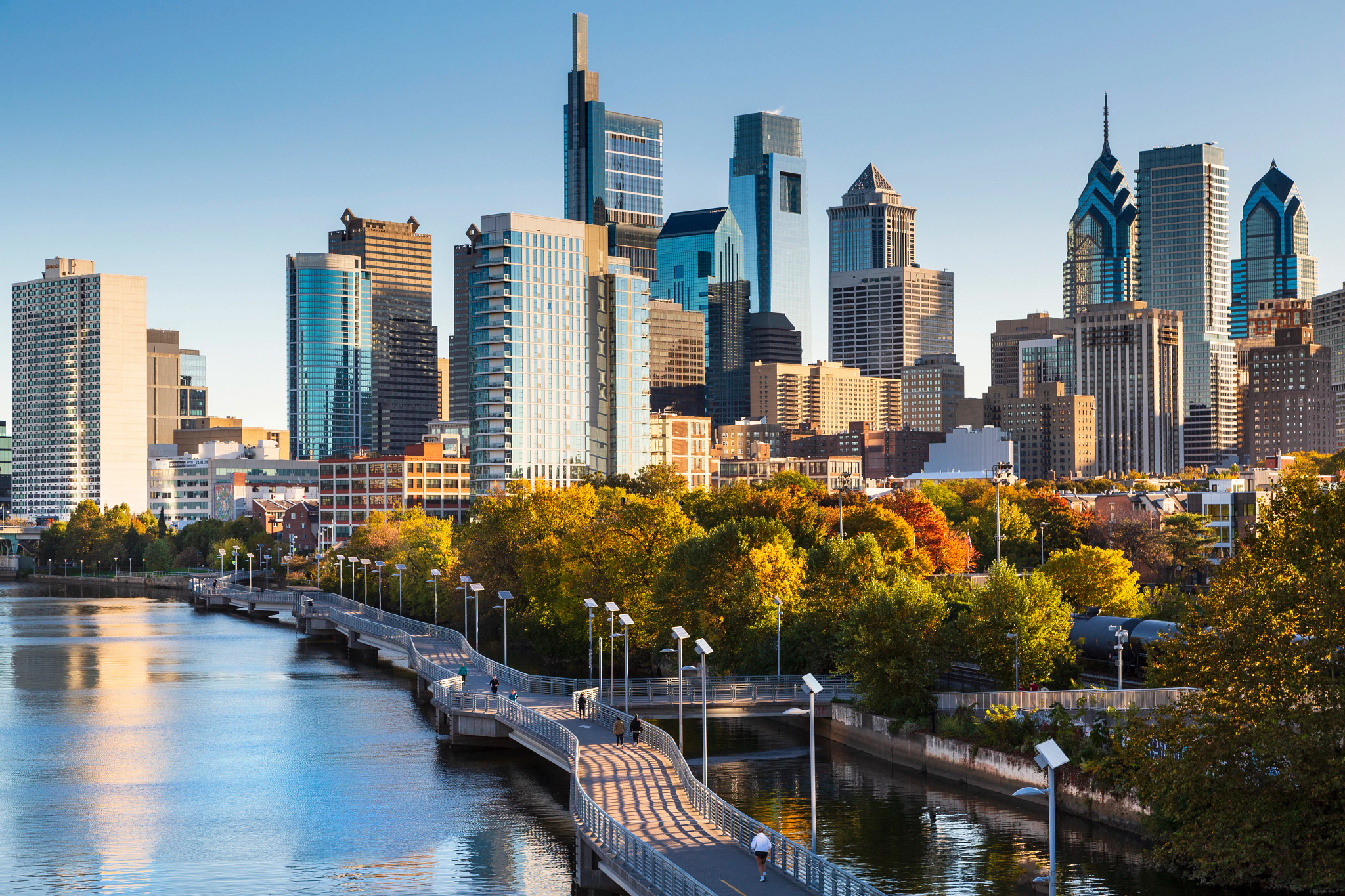 Philadelphia skyline over the Schuylkill River and boardwalk park.