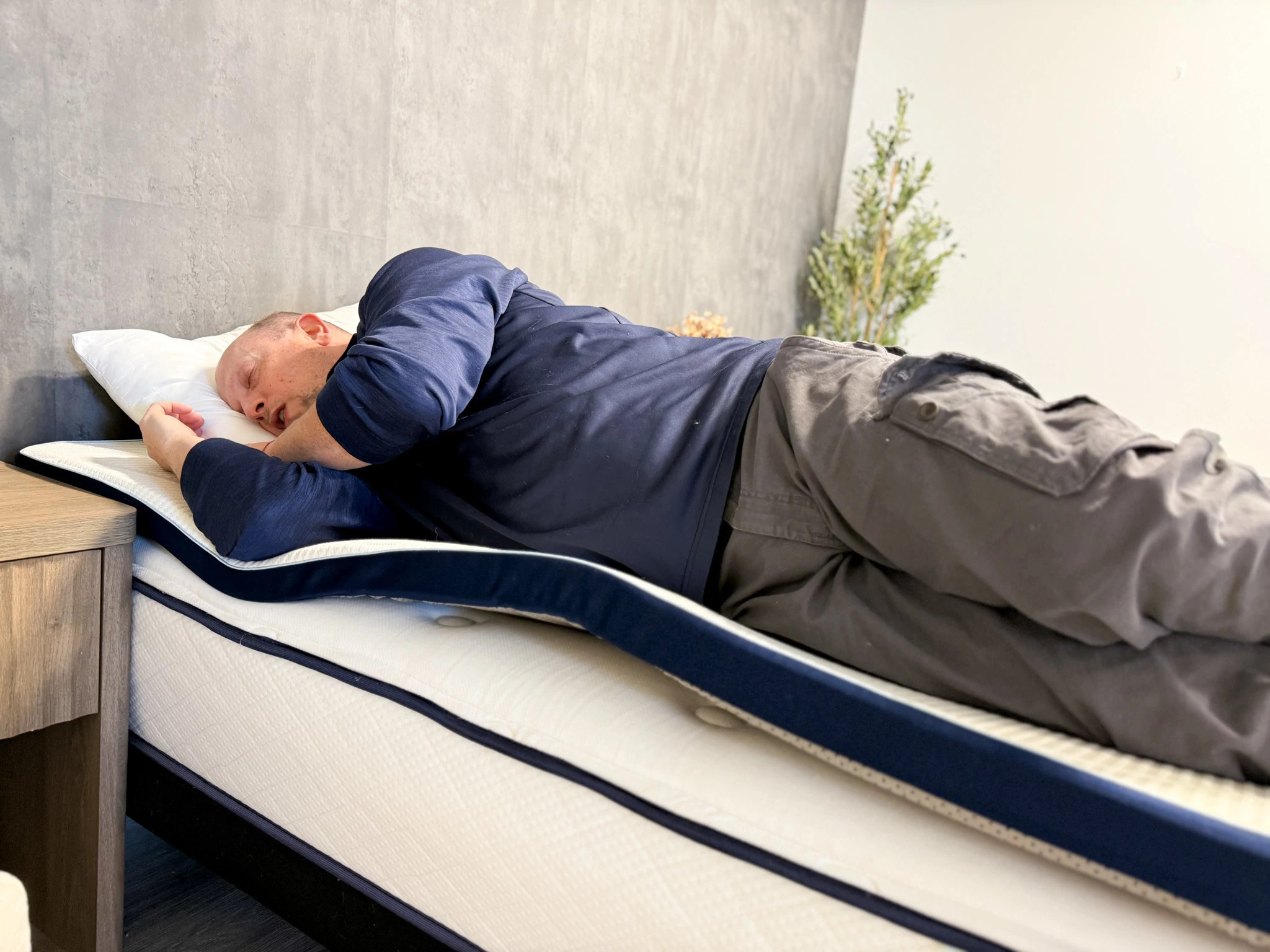 Man lies on his side in bed with his eyes closed
