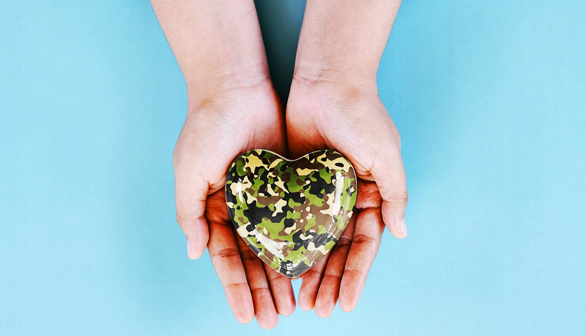 How to thank a Vietnam veteran hands hold a camo heart on a blue background