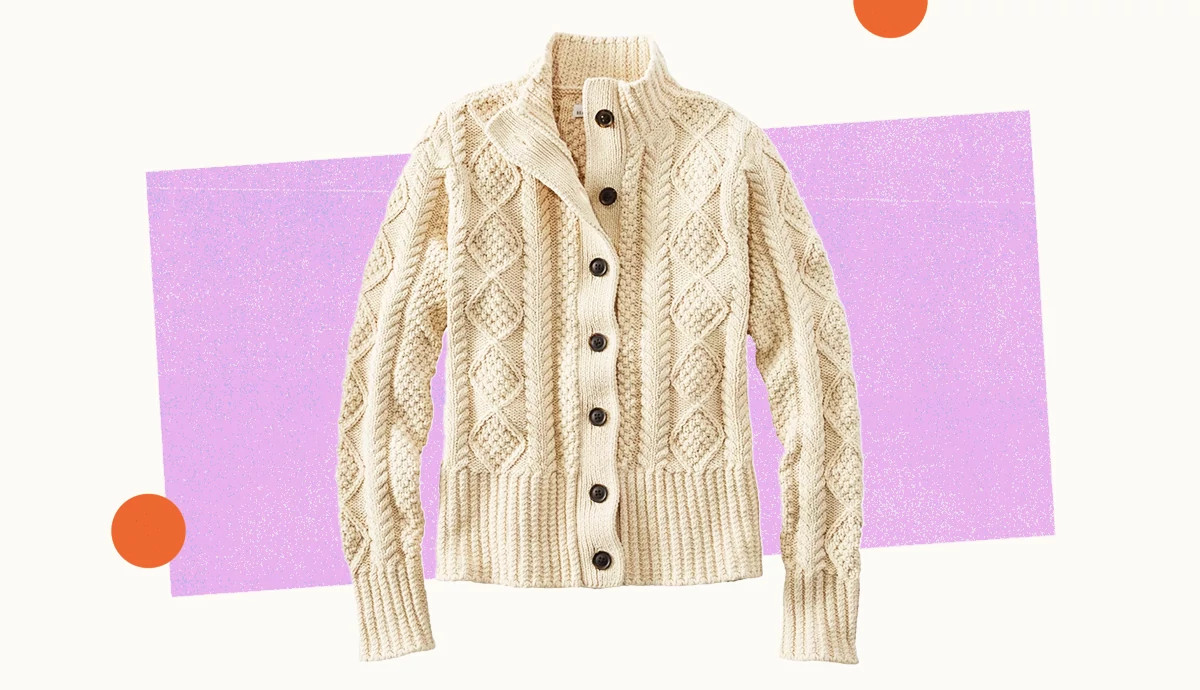 a cable knit button front cardigan in ivory over a background with lavender and orange shapes