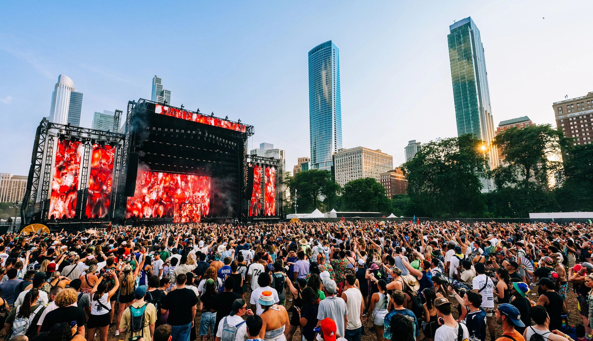 2024 Lollapalooza music festival Big stage with a lot of people in the crowd; tall buidlings in the background