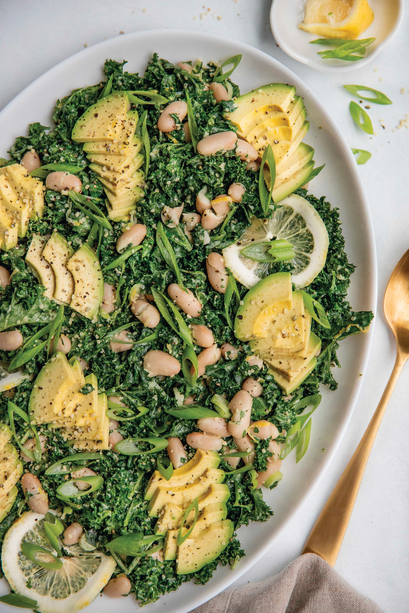 Kale, hemp hearts, white beans, avocado and dressing on dish