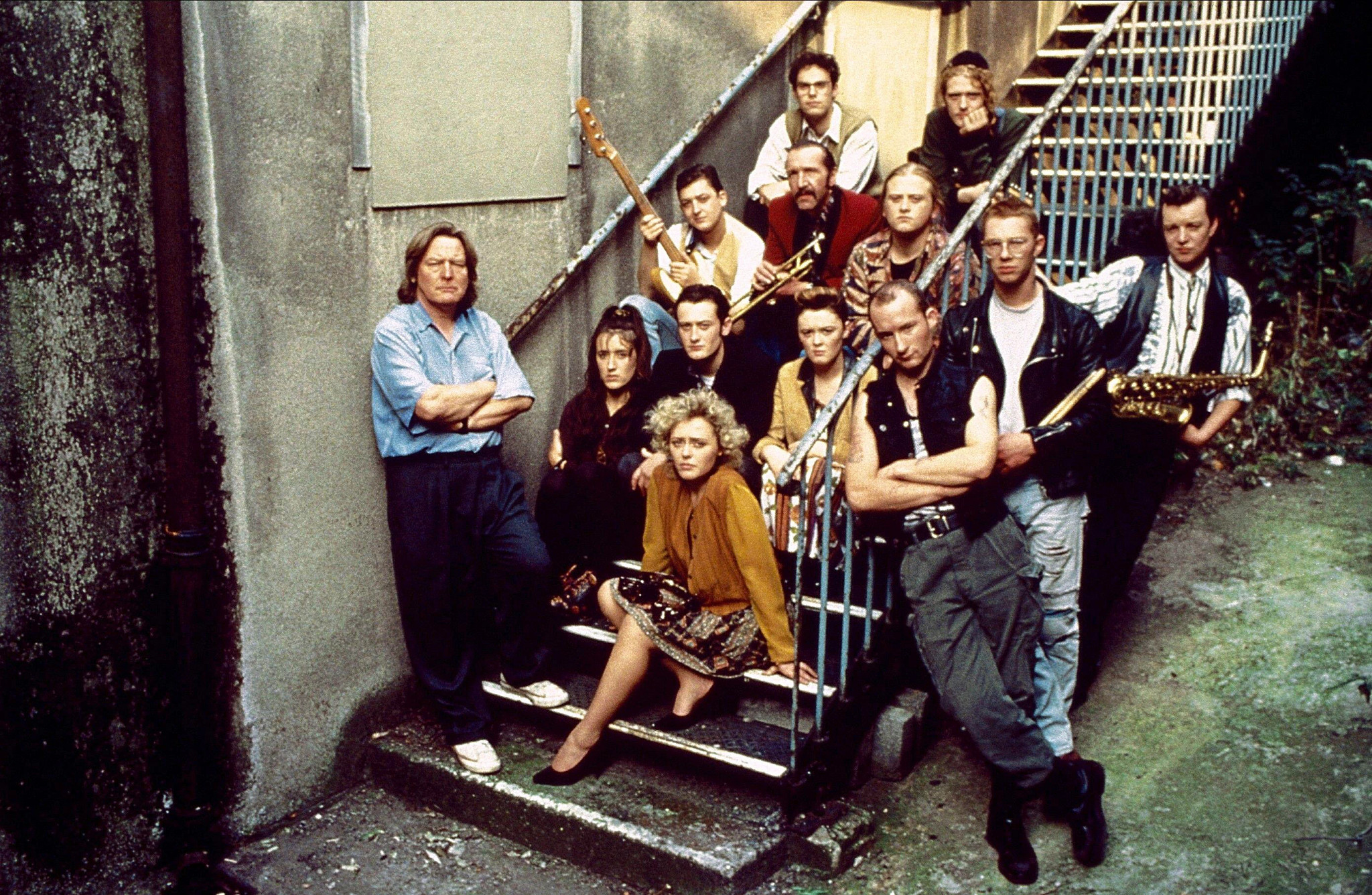 a big group shot of the cast of the commitments posing on a stairway
