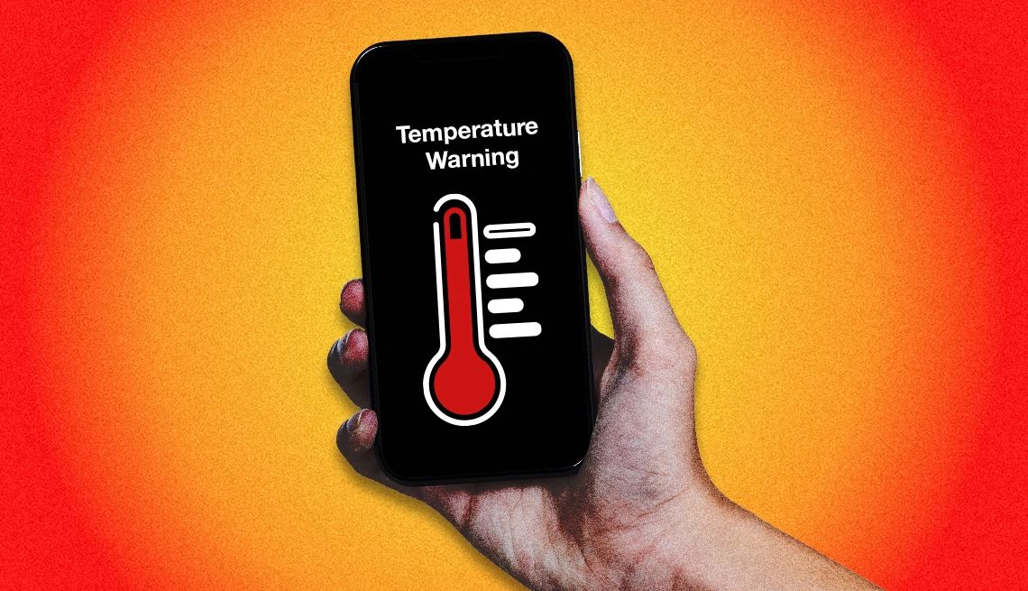 Hot Phone a person holding a smartphone with a temperature warning displayed on the screen