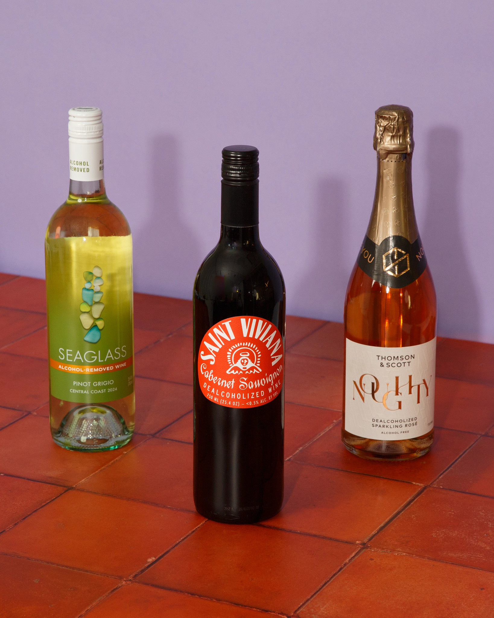 A photo shows, from left to right, three nonalcoholic wines: Seaglass Alcohol-Removed Pinot Grigio, Saint Viviana Non-Alcoholic Cabernet Sauvignon and Noughty Non-Alcoholic Sparkling Rosé.