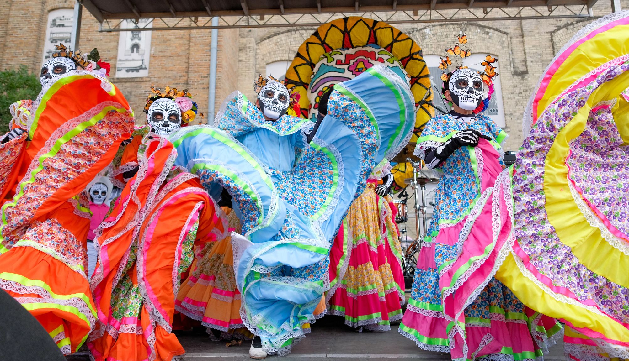 Dia De Los Muertos performers dressed in dia de los muertos costumes