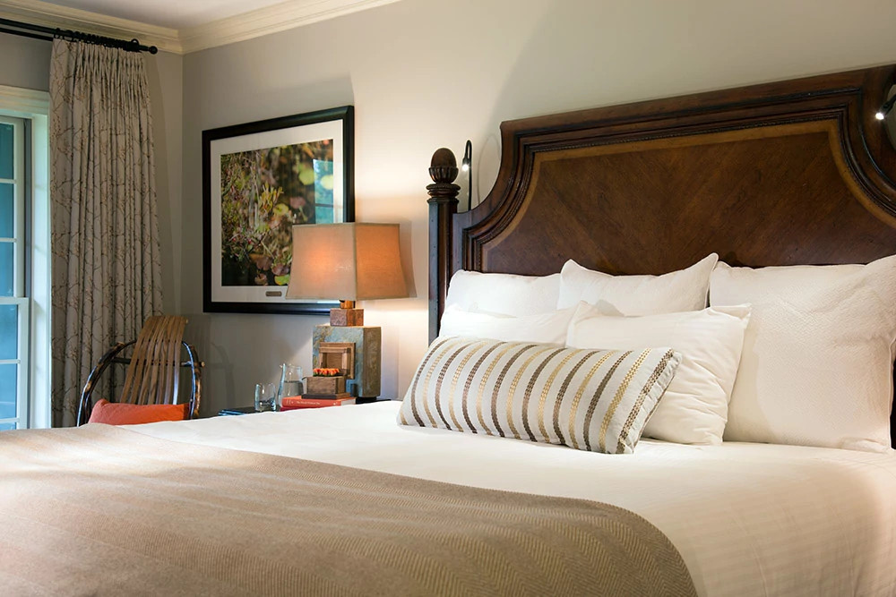 Luxurious spa bedroom with white linens and wooden headboard at a Pennsylvania retreat
