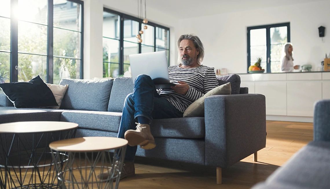 Too much couch time can be harmful A man sitting on a couch with a laptop on his lap