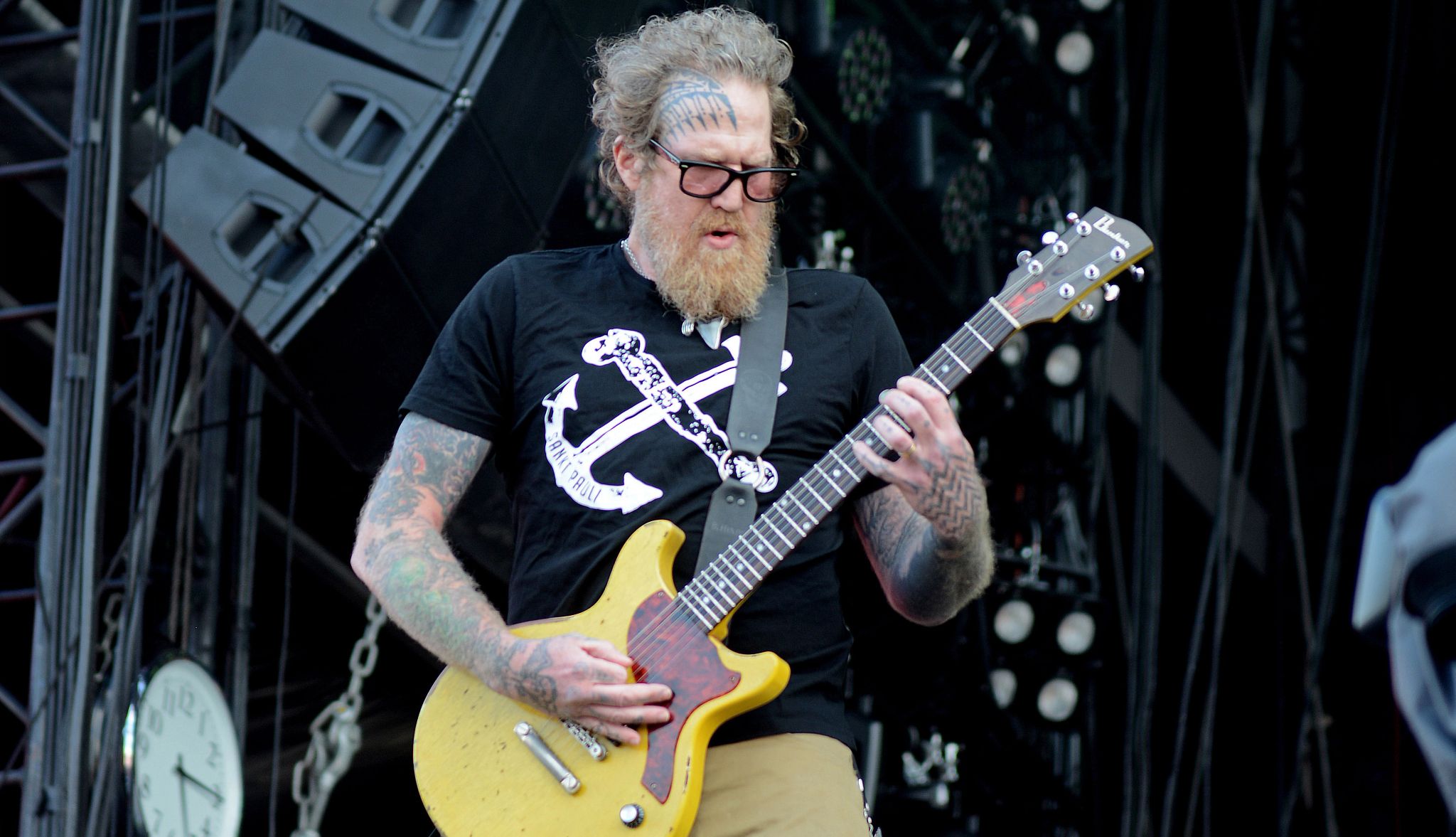 Brent Hinds, Former Mastodon Singer-Guitarist, Dies at 51 bearded, tattooed rock musician with glasses and long hair playing a guitar