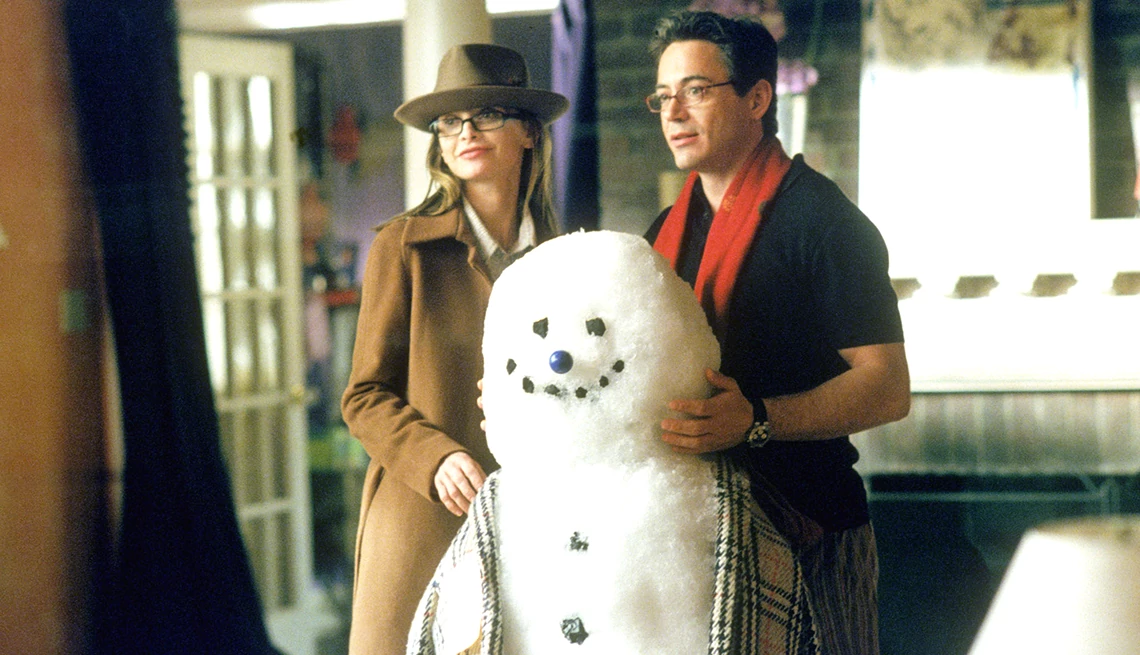 Calista Flockhart and Robert Downey Jr. standing behind a snowman in the television series Ally McBeal